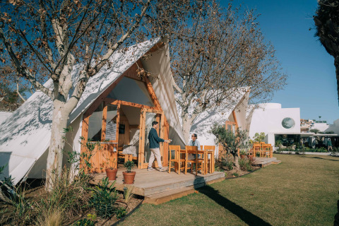Buitenaanzicht van lodge Hanna bij Camping Costa del Sol Glamping Village met gasten op het terras.