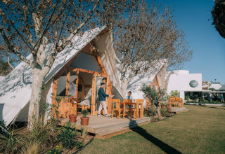 Außenaufnahme der Hanna-Lodge im Camping Costa del Sol Glamping Village, Gäste auf der Terrasse entspannen.