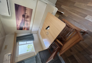 Essbereich der Bungalow Essential Banya bei TAIGA Delta de l'Ebre, Spanien, mit Holztisch und Stühlen.