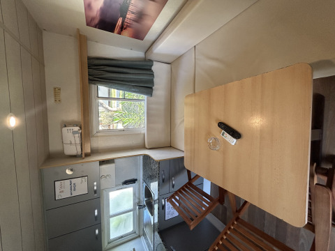 Binnenzicht van Bungalow Essential Banya bij TAIGA Delta de l'Ebre, Spanje, met keuken en eettafel.