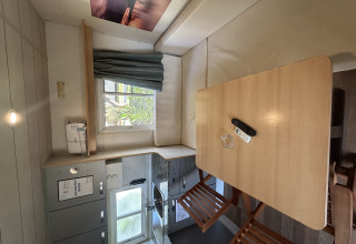 Vista interior de Bungalow Essential Banya en TAIGA Delta de l'Ebre, España, con cocina y mesa de comedor.