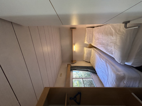 Een smalle slaapkamer in Bungalow Essential Banya bij TAIGA Delta de l'Ebre in Spanje met twee eenpersoonsbedden.