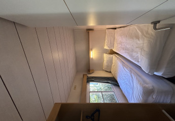 Un dormitorio estrecho en Bungalow Essential Banya de TAIGA Delta de l'Ebre, España, con dos camas individuales.