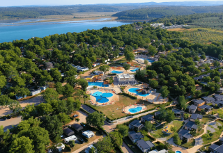 Luchtfoto van Camping Lanterna vakantiepark in Istrië, Kroatië met zwembaden, groen en kustlijn nabij.