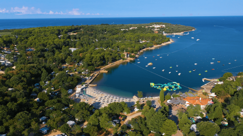 Vista aérea de Camping Lanterna en Istria, Croacia, con playa, bosque y el mar azul de fondo.