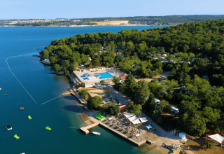 Vista aerea del campeggio Lanterna in Istria, Croazia, con spiaggia, piscina e aree verdi sul mare.