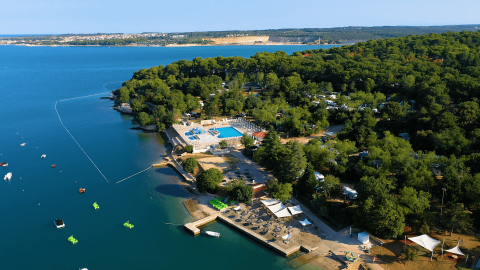 Vista aérea del Camping Lanterna en Istria, Croacia, con playa, piscinas, vegetación y área de carpas.