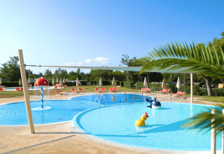 Kindvriendelijk zwembad met waterspeelgoed en ligstoelen bij Camping Lanterna, Istrië, Kroatië op een zonnige dag.