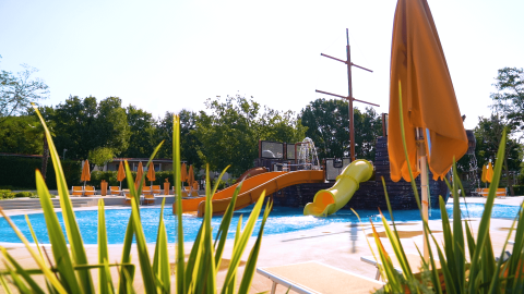 Piscina al aire libre con toboganes y tumbonas en Camping Lanterna, parque de vacaciones en Istria, Croacia.