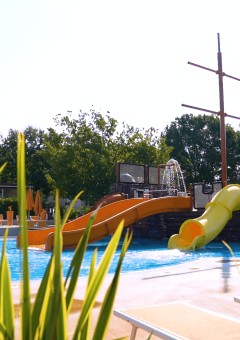 Piscina al aire libre con toboganes y tumbonas en Camping Lanterna, parque de vacaciones en Istria, Croacia.