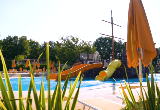Buitenzwembad met glijbanen en ligbedden bij Camping Lanterna vakantiepark in Istrië, Kroatië.