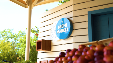 Cartel de 'Green Market' en Camping Lanterna, un parque vacacional en Istria, Croacia, junto a manzanas frescas.