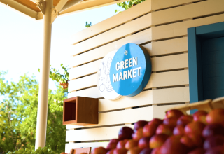 Skiltet 'Green Market' på Camping Lanterna, en feriepark i Istrien, Kroatien, ses ved siden af friske æbler.