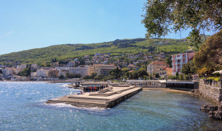 Vista costera cerca de Tar, Istria, Croacia, con edificios, colinas verdes y aguas azules brillantes.