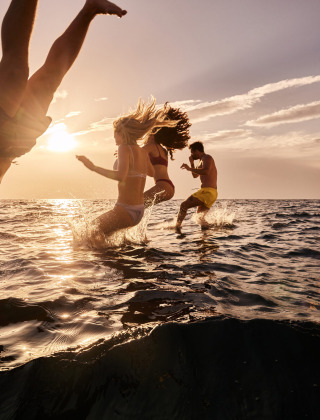 Personas saltando desde un barco al mar al atardecer cerca de Tar, Istria, Croacia, disfrutando el verano.