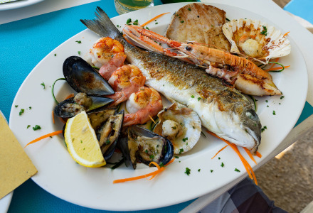 Un plato de pescado y mariscos frescos de Tar, Istria, Croacia, servido con rodajas de limón y hierbas.
