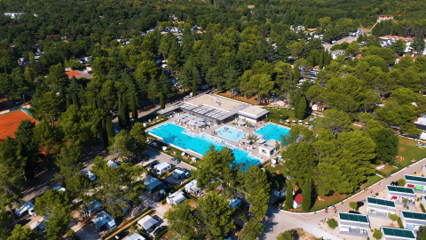 Vista aerea di Camping Valkanela in Istria, Croazia, con piscine, camper e alberi rigogliosi.