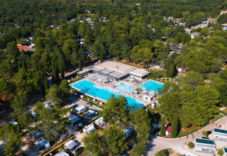 Aerial view of Camping Valkanela in Istria, Croatia, featuring pools, campers, and lush green trees.
