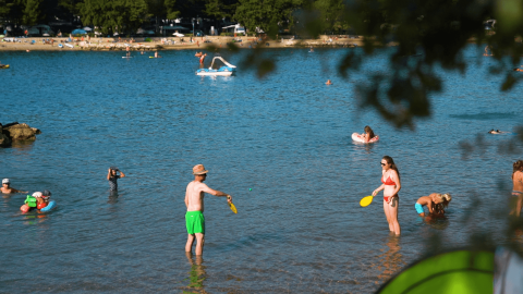 Personas juegan y se relajan en el agua junto a la playa en Camping Valkanela, Istria, Croacia, en verano.