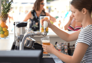 Donna che serve una birra alla spina al bar del Camping Valkanela, parco vacanze in Istria, Croazia.