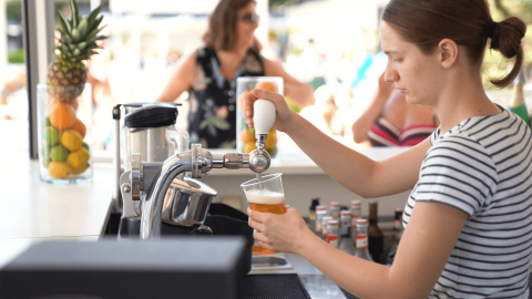 Donna che serve una birra alla spina al bar del Camping Valkanela, parco vacanze in Istria, Croazia.