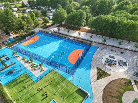 Vista aérea de canchas deportivas con baloncesto, tenis y zona de juegos en Camping Valkanela, Istria, Croacia.