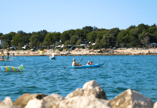 Folk nyder kajaksejlads og vandsjov i havet ved Camping Valkanela, en feriepark i Istrien, Kroatien.