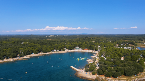 Aerial view of Camping Valkanela, a holiday park in Istria, Croatia, showing coastline and greenery.