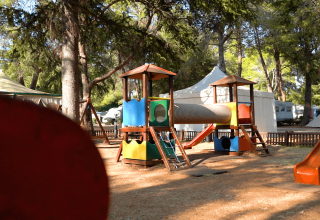 Area giochi colorata tra gli alberi con scivoli, tunnel e tende al Camping Valkanela, Istria, Croazia.