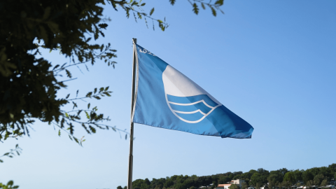 Bandera Azul ondeando en Camping Valkanela en Istria, Croacia, indicando alta calidad ambiental de la playa.