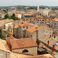 Vista de un parque vacacional con opciones de glamping y tejados rojos en una ciudad pintoresca.