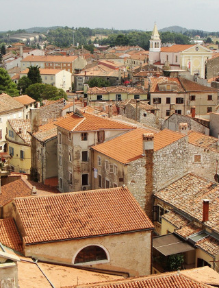 Vista de un parque vacacional con opciones de glamping y tejados rojos en una ciudad pintoresca.
