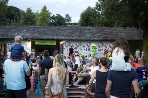 Gezinnen genieten van een kindershow buiten bij de Mini Club in Altomincio Family Park, Lombardije.