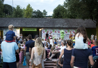 Famiglie assistono a uno spettacolo per bambini all’aperto ad Altomincio Family Park, in Lombardia.