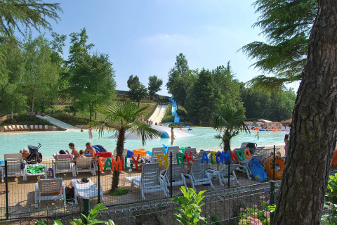 Parque acuático familiar en Altomincio Family Park, Lombardía, Italia, con toboganes y tumbonas al sol.