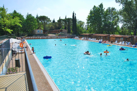 Grande piscina all'aperto con persone e lettini presso Altomincio Family Park, Lombardia, Italia.