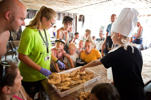 Niños y adultos disfrutan de una actividad de cocina juntos en Altomincio Family Park en Lombardía, Italia.