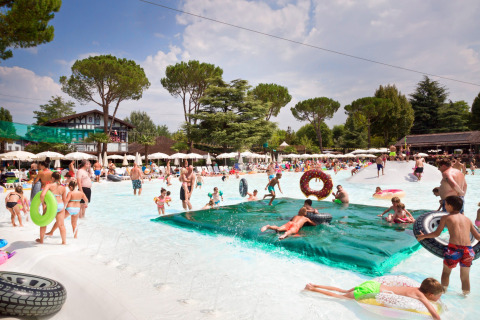 Bambini e famiglie si divertono nella piscina dell’Altomincio Family Park, in Lombardia, Italia, in una giornata soleggiata.