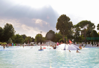Børn og familier nyder en stor swimmingpool med solstole i Altomincio Family Park, Lombardiet, Italien.