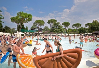 Mange familier nyder en solrig dag ved swimmingpoolen med baderinge i Altomincio Family Park, Lombardiet.