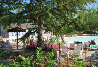 Billede af solstole, parasoller og en swimmingpool omgivet af træer i Altomincio Family Park, Lombardiet.