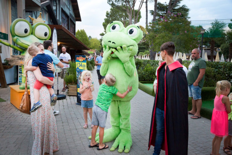 Niños y adultos conocen a una mascota rana en Altomincio Family Park, parque vacacional en Lombardía, Italia.