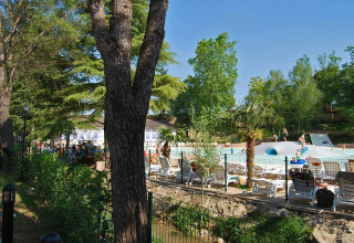 Udsigt over Altomincio Family Park i Lombardiet, Italien, med swimmingpool, liggestole og grønne træer.