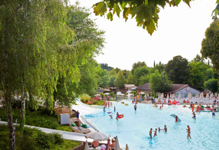 Feriepark i Lombardiet, Italien med pool, familier og børn, omgivet af grønne træer og afslappende natur.