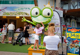 Un niño toca una gran estatua de rana en Altomincio Family Park, un parque de vacaciones familiares en Lombardía, Italia.