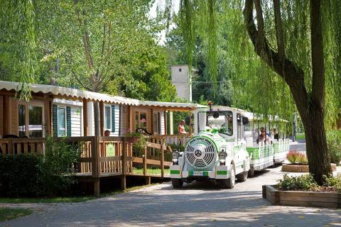 Un piccolo trenino turistico passa davanti alle case mobili ad Altomincio Family Park, in Lombardia, Italia.