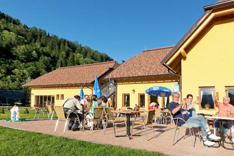 Outdoor dining at Camping Bella Austria holiday park in Styria, Austria, surrounded by lush green nature.
