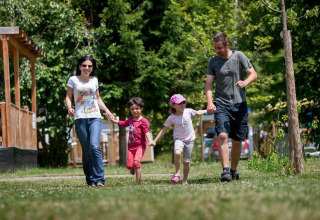 Een gezin wandelt samen op Camping Bella Austria, een vakantiepark in Stiermarken, Oostenrijk.