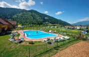 Udendørs pool med liggestole og bjerge i baggrunden på Camping Bella Austria i Stiermarken, Østrig.