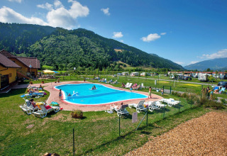 Outdoor pool with sun loungers and mountain views at Camping Bella Austria holiday park in Styria, Austria.